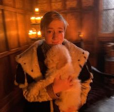 a woman holding a white teddy bear in her arms and wearing a fur coat over her shoulders