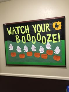 a sign that says watch your booooze on the side of a wall in an office