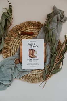 a book sitting on top of a table next to some leaves and a basket with a pair of boots