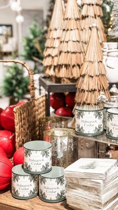 christmas decorations and candles are on display in a store with red balls, baskets and other holiday decor