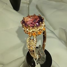 Aaa Rated Amethyst Ring With Orange Sapphires And Zircons In Sterling Silver, With Parts Covered In 14k Rose Gold. 6ctw Gold Amethyst Ring With Halo Setting, Formal Pink Gold Ring With Center Stone, Formal Pink Gold Ring Jewelry, Gold Amethyst Ring With Halo Setting, Fine Jewelry, Formal Pink Amethyst Ring With Gemstone Accents, Formal Pink Gold Sapphire Ring, Elegant Gold Amethyst Ring With Halo Setting, Formal Rose Gold Topaz Ring With Accent Stones, Rose Gold Amethyst Ring With Accent Stones