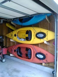 two kayaks are parked in the garage next to each other