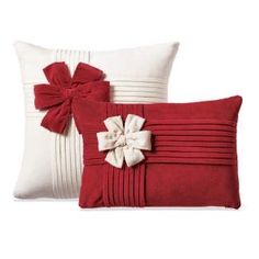 two red and white pillows with bows on them