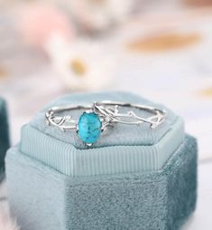 a turquoise stone ring sitting on top of a blue box