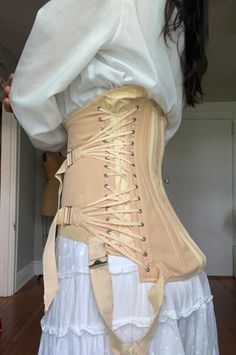 Amazing vintage triple fan corset. Labeled "Freeman Surgical Corset" with hooks and eye closures and lace up sides. There are ventilation flaps under each arm and elastic at the armpits and hips. Adjusts at sides with triple fan lacing. Has two very strong surgical steel boning rods in the back.  Good vintage condition- some discoloration and fading.  This item has been hand washed. There is some fraying on straps as well as discolorations, pictured.  No sizing tag, estimated S/M. Please see mea Fan Lacing Corset, Fitted Beige Corset Belt With Corset Back, Beige Fitted Corset Belt With Corset Back, Fitted Vintage Corset For Festivals, Vintage Fitted Corset For Festival, Vintage Cream Underbust Corset, Beige Underbust Corset Belt, Vintage Overbust Corset With Boning, Vintage Overbust Corset Dress With Boning