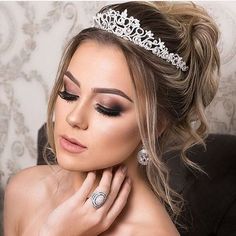 a beautiful woman wearing a tiara and diamond jewelry on her head, posing for the camera