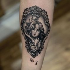 a woman's face in a frame tattoo on the leg