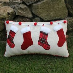 a red and white christmas stocking pillow on the grass