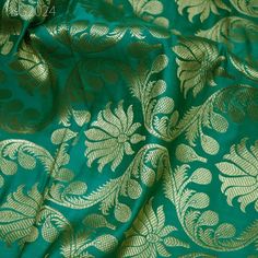 green and gold brocaded fabric with large leaves