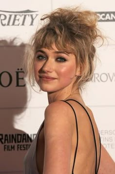 a close up of a person on a red carpet wearing a black dress and posing for the camera