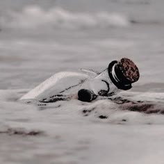 a person is swimming in the ocean with a hat on their head and wearing a wet suit