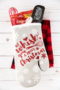 an oven mitt with the words merry written on it next to other kitchen items