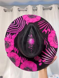 Halloween hat Brim is about 3.75" wide  Content: Vegan Suede Adjustable to fit your head better if needed  Elevate your style with this stunning hand-painted wide-brim fedora, crafted from luxurious vegan suede in a Vibrant Pink and Black palette. This one-of-a-kind piece is adorned with intricate designs featuring a flowers and vines winding gracefully around the crown, celestial stars, delicate leaves, The Sun and  phases of the moon. Each flower is meticulously painted with thick, textured strokes, adding a unique tactile dimension to the hat's sophisticated design. This fedora isn't just a hat; it's a wearable work of art. Perfect for making a statement at festivals, special events, or just adding a touch of magic to your everyday outfits. Whether you're dressing up or down, this versa Halloween Costume Hats, Hat Halloween Costume, Black Palette, Pink Flower Crown, Celestial Stars, Halloween Hat, Suede Hat, Crown Hat, Festival Hat