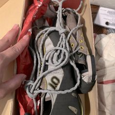 someone is unpacking their shoes in a box with the shoelaces still attached