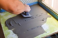 a person using a sponge to paint a piece of furniture