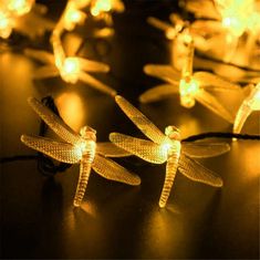 three lighted dragonflies sitting on top of a table