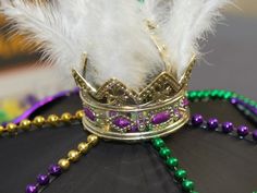 a crown on top of a hat with beads and feathers attached to the headband