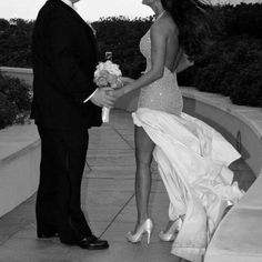 a man in a tuxedo and a woman in a dress holding a bouquet