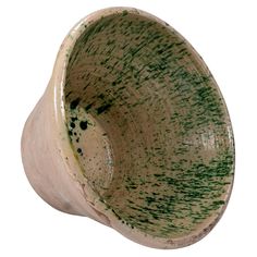 a close up of a ceramic bowl on a white background with green speckles