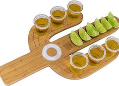 a wooden tray topped with shots and limes