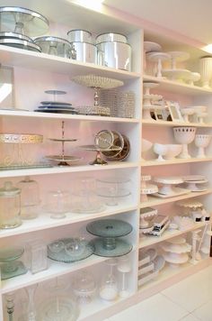 a white shelf filled with lots of plates and bowls