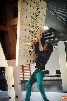 a man climbing up the side of a wooden structure