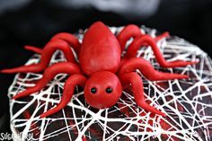 a red spider cake with white icing and sprinkles on the top