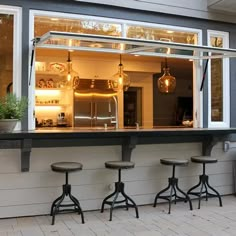 three stools sit in front of a bar with an open window on the side