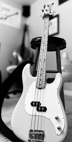 a white bass guitar sitting on top of a chair