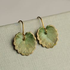 These olive green leaf earrings are brass charms with some amazing detail, which have been carefully treated, painted and varnished to bring out beautiful tones and depth of colour and to show the incredible veining and other details of the metal.  These are coloured a beautiful, delicate and multi toned olive green colour.   They are designed to be reminiscent of the beautiful, softly coloured lily pads found in Art Nouveau paintings. They are handmade in our Edinburgh studio and no two pairs are quite the same!  Our Leaf Earrings are available in two finishes: soft matte or a shiny glass appearance. The colour and level of detail on the earrings are exactly the same regardless of which you choose.  We've included an image for a better idea.   Each leaf is 15mm long. We offer these leaf e Green Leaf Earrings, Green Brass Earrings Nature-inspired, Nature-inspired Green Brass Jewelry, Leaf-shaped Brass Earrings For Gift, Leaf-shaped Brass Earrings As Gift, Green Brass Earrings As Gift, Green Brass Earrings For Gift, Green Leaf-shaped Earrings For Pierced Ears, Green Leaf-shaped Earrings For Gift