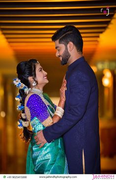 a man and woman standing next to each other in front of a ceiling with lights