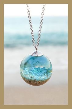 Keep the ocean close with an ocean necklace that captures the water and beach sand in resin. The perfect ocean necklace for beach lovers. This stunning beach jewelry gives you a tiny piece of beach and ocean in 3D! Follow the link to beachblissdesigns.com to learn more and see other version of ocean beach necklaces. Necklace For Beach, Resin Jewelry Pendants, Sand Necklace, Beach Resin, Dreamy Ocean, Ocean Necklace