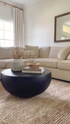 a living room filled with furniture and a large mirror on the wall above the couch