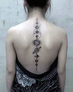 the back of a woman's neck with planets and stars on it