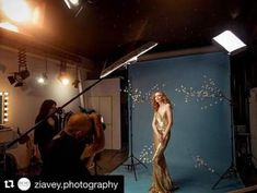 a woman in a gold dress is posing for a photo while two people are behind her