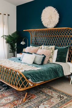 a bed with green sheets and pillows in a bedroom next to a rug on the floor