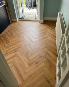 an open door leading into a room with wood flooring on the outside and inside