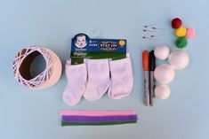 craft supplies laid out on top of a blue surface with balls of yarn, scissors and markers