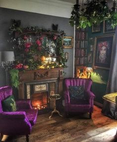 a living room with two purple chairs and a fire place in the middle of it