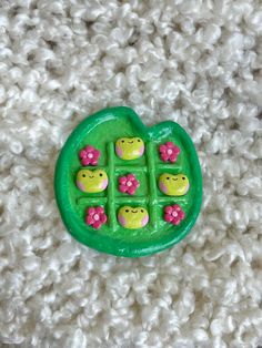 a green brooch with pink flowers on it