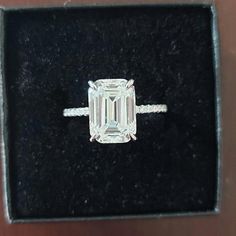 an emerald cut diamond ring in a box