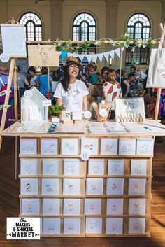 a woman standing behind a table with lots of cards on it