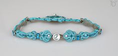 a blue beaded bracelet on a white surface