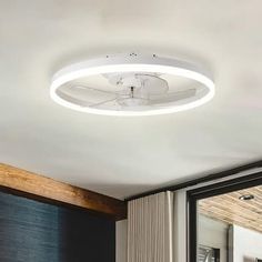 a white ceiling fan sitting on top of a wooden floor next to a sliding glass door