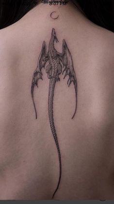 a woman's back with a dragon tattoo on it