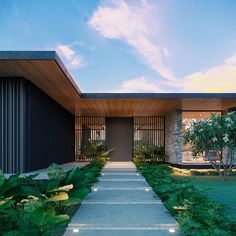 the entrance to a modern home surrounded by greenery