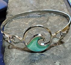 Beautiful wave hook bangle, stainless steel with dichroic glass. Size 7.5 inch bangle Handmade Silver Wavy Jewelry, Adjustable Silver Bracelets With Ocean-inspired Style, Adjustable Silver Bracelet With Ocean-inspired Style, Adjustable Silver Ocean-inspired Bracelets, Silver Adjustable Ocean-inspired Bracelets, Adjustable Wavy Sterling Silver Jewelry, Nickel-free Stainless Steel Bangle, Adjustable Ocean-inspired Metal Jewelry, Ocean-inspired Adjustable Nickel-free Jewelry