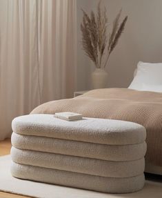 a bed sitting on top of a wooden floor next to a white rug and window