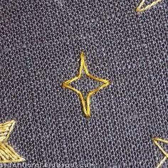 a close up view of some gold stars on a gray fabric