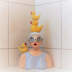 a woman with goggles and rubber ducks on her head in a bathroom stall,